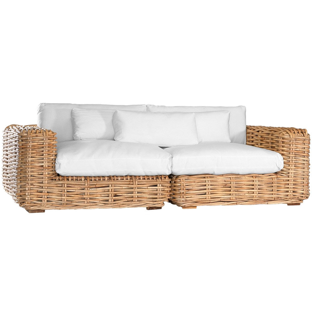 Natural wicker corner chair with thick white cushions, showcasing a coastal-inspired design perfect for indoor and outdoor settings