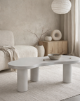 Zuburu coffee table in white hydro dipped finish with organic shaped top and cylindrical legs styled in a soft neutral living room.
