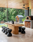 A contemporary dining table setting featuring KULALA Living’s sleek black cutlery, speckled ceramic plates, and a soft linen napkin on a warm timber table. Styled with black sculptural vases and delicate dried foliage, this setting embodies modern elegance and refined simplicity