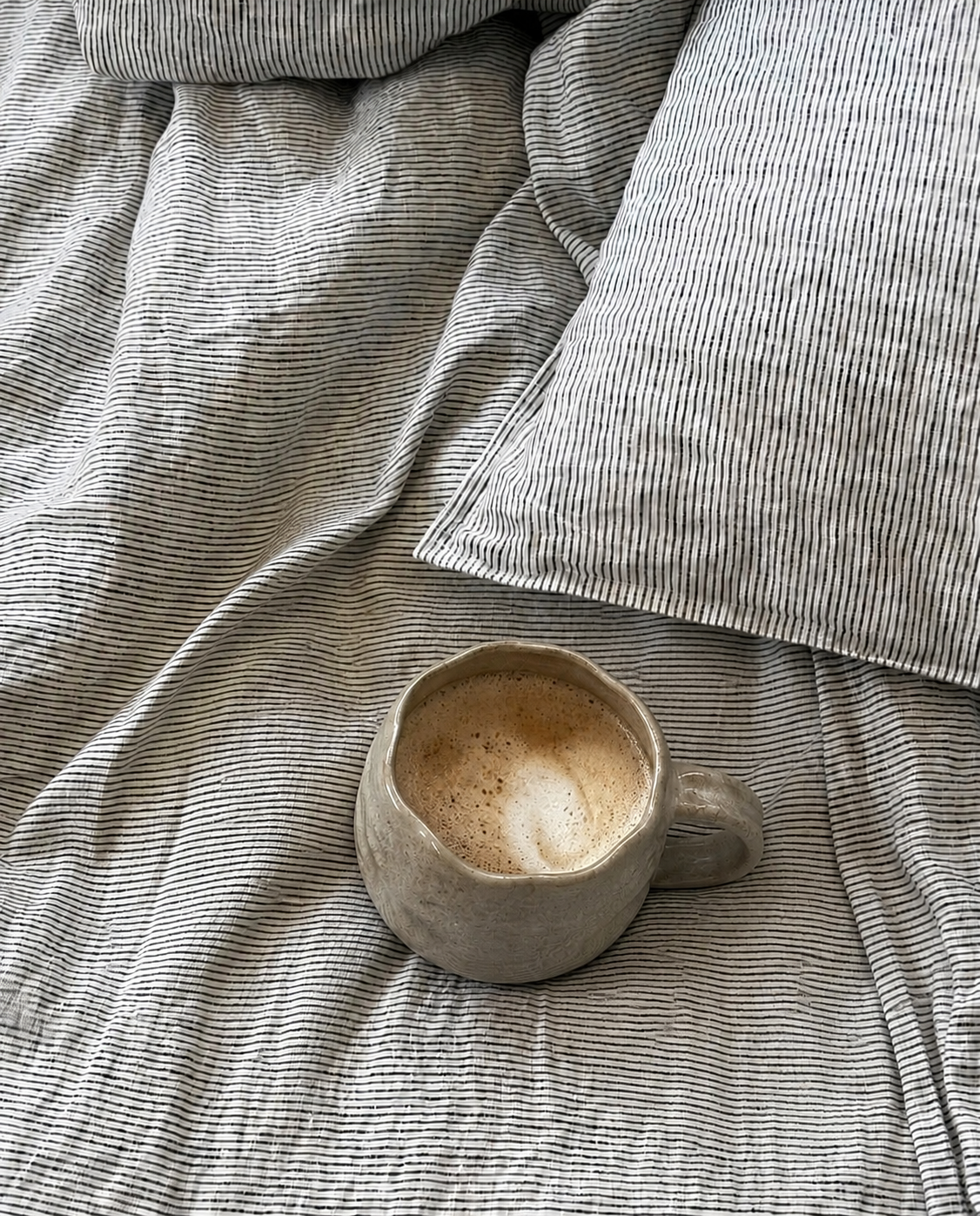 SOL Linen Ink Pinstripe Linen Duvet Cover shown on a bed, featuring a sleek pinstripe pattern and soft linen fabric for stylish bedding.