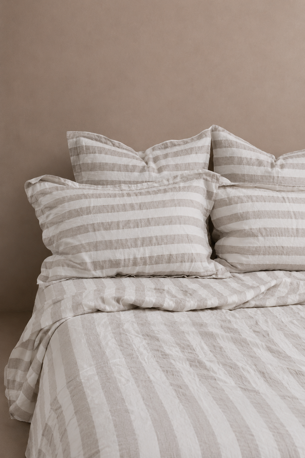 Soft beige SOL Linen Noemi linen duvet cover on a bed, showcasing its textured fabric and relaxed bedding style in a cozy bedroom setting.