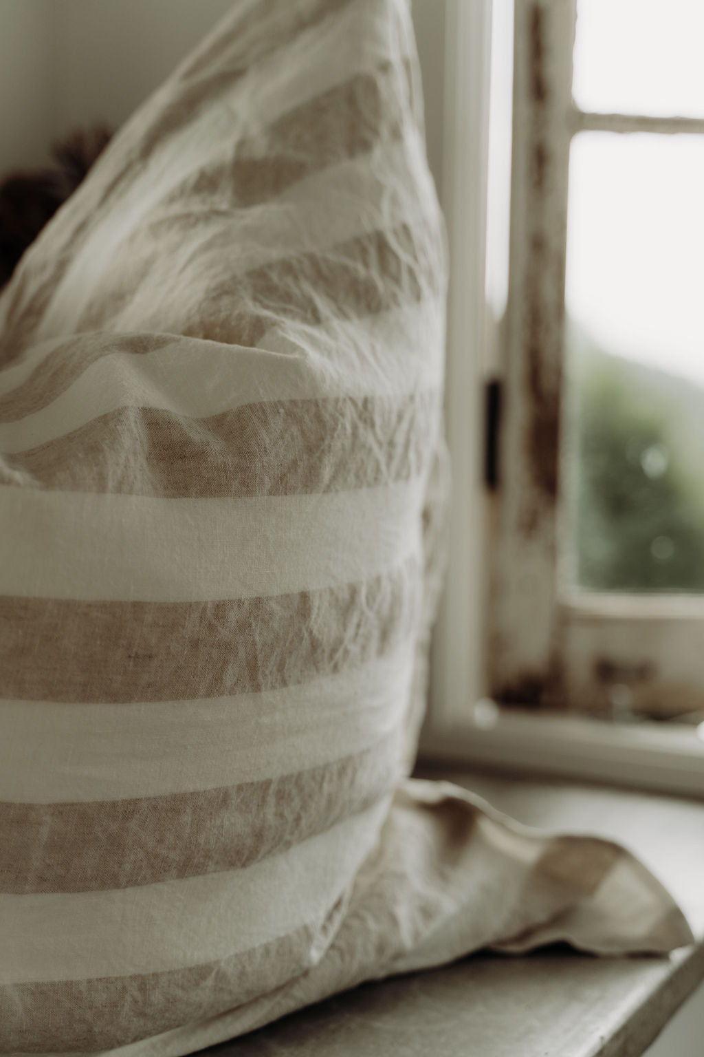 Pair of SOL Linen Noemi European pillowcases in soft linen fabric, shown on a cozy bedding setup for a relaxed bedroom look.