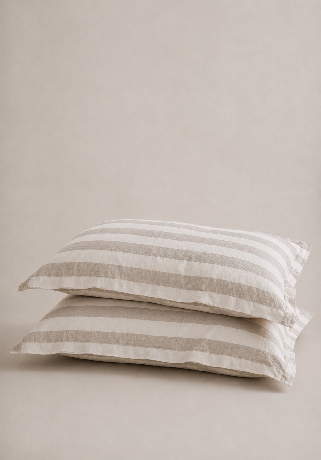 Set of two SOL Linen Noemi linen pillowcases for bedding, shown in a cozy bedroom setting with soft natural lighting.
