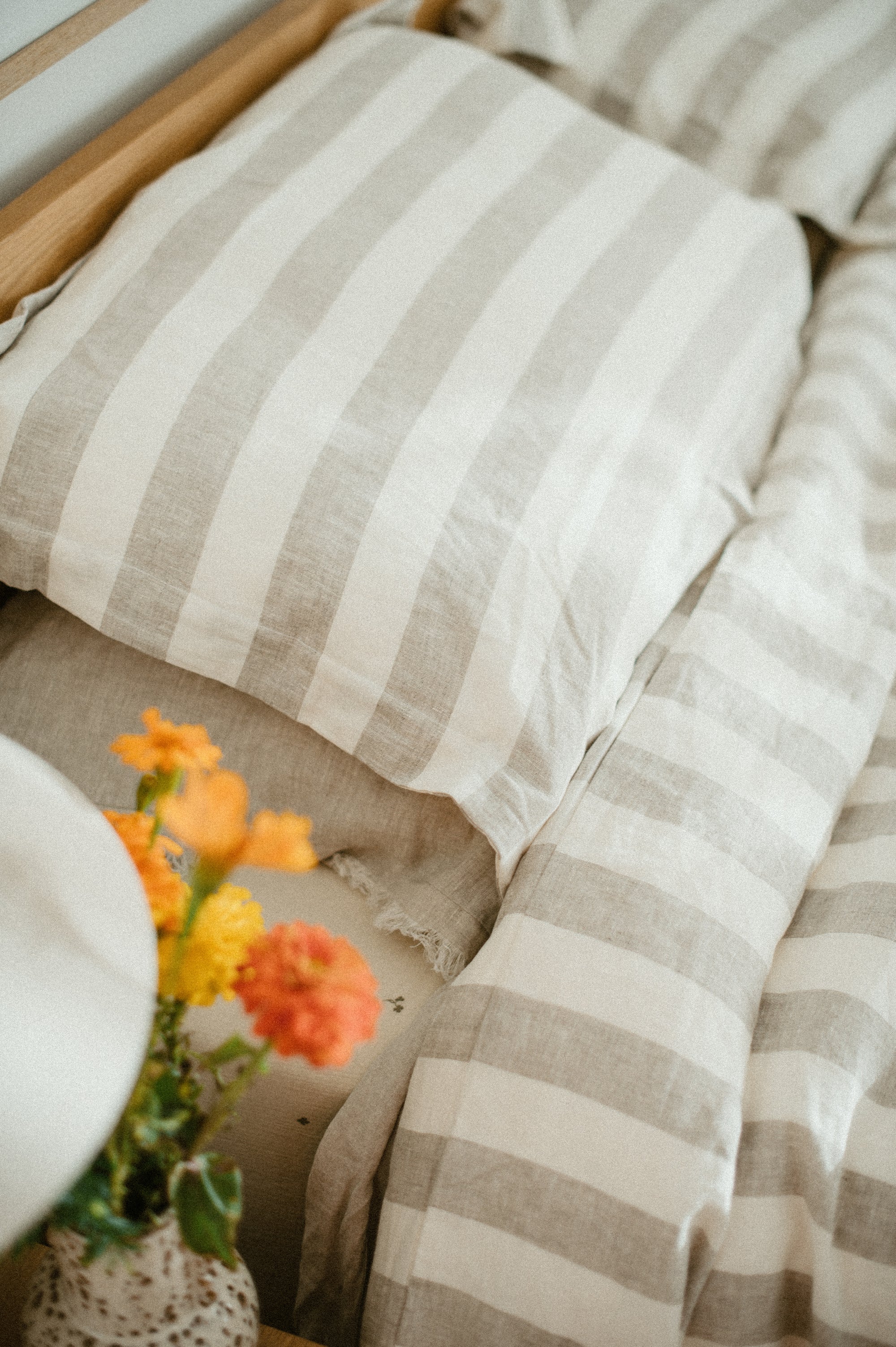 Set of two SOL Linen Noemi linen pillowcases on a bed, showcasing soft, natural fabric in a cozy bedding setting.