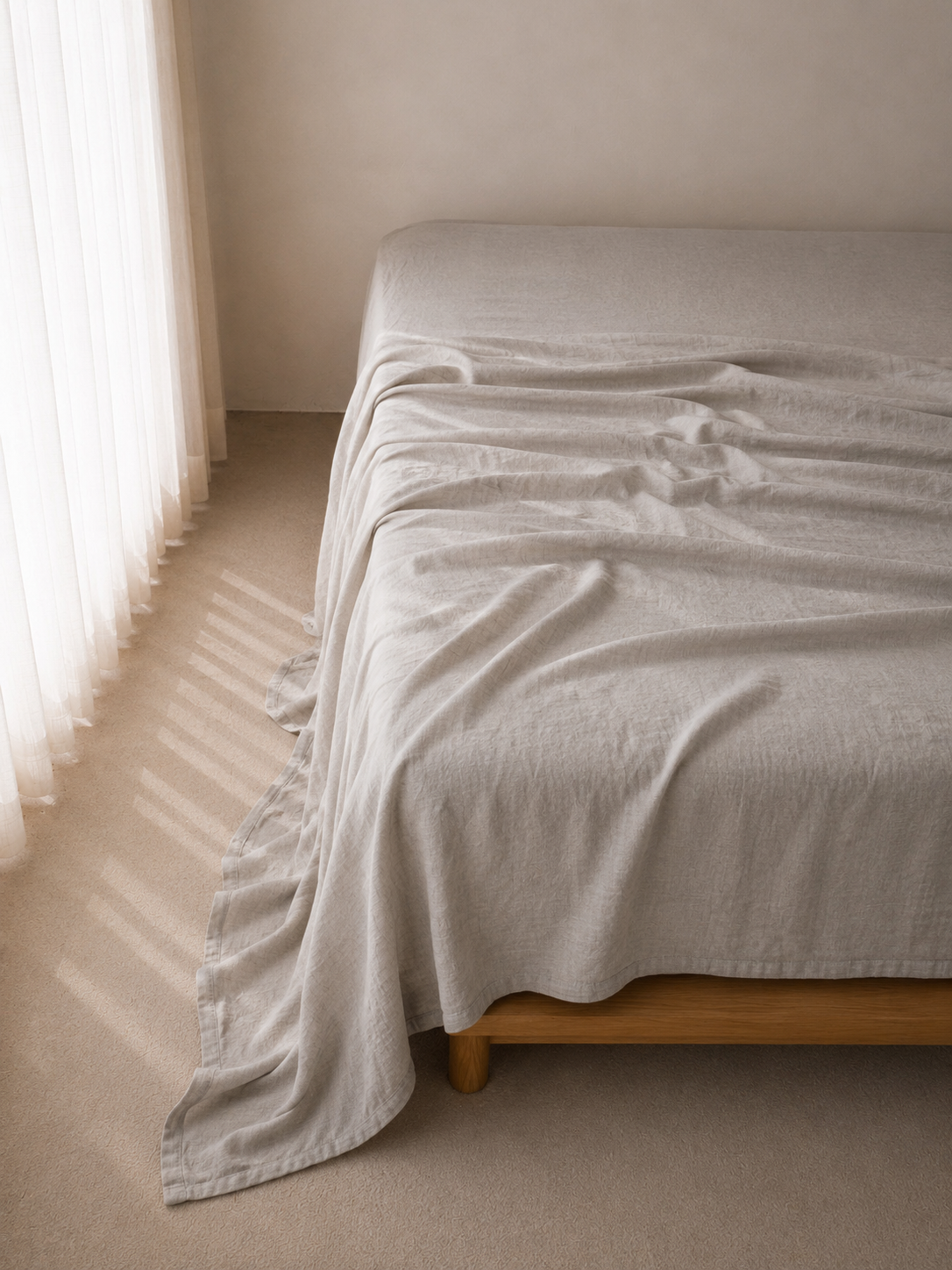 SOL Linen Sable linen fitted sheet laid on a bed with a cozy, minimalist bedroom setting, highlighting its soft, breathable fabric.