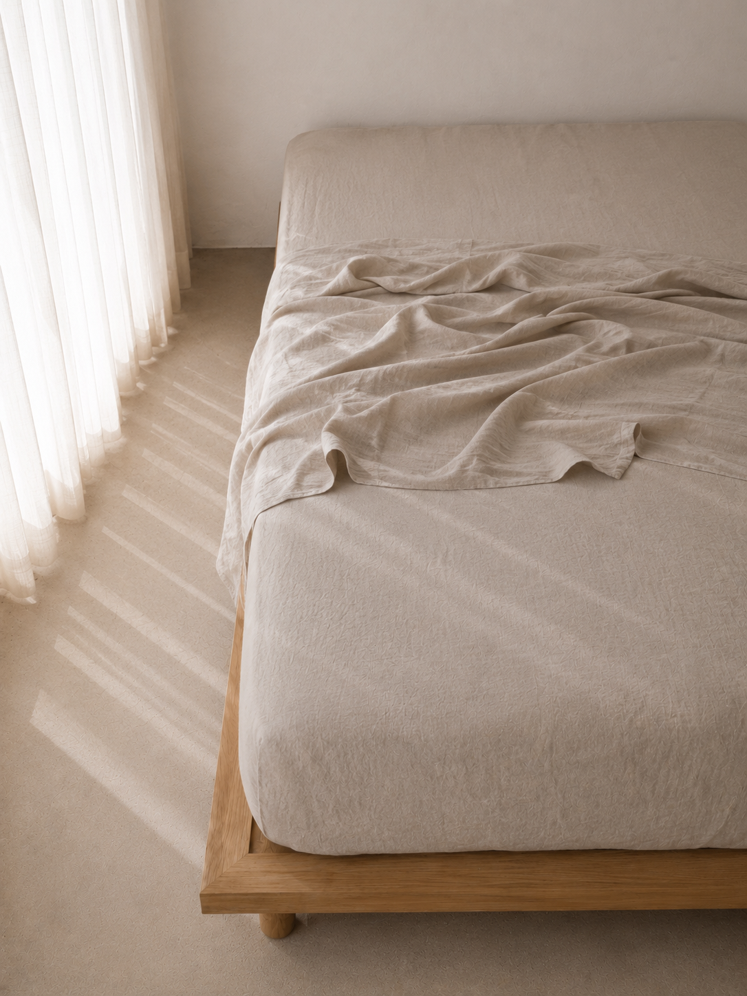 SOL Linen Sable linen fitted sheet on a bed, showcasing soft, breathable bedding in a cozy bedroom setting.