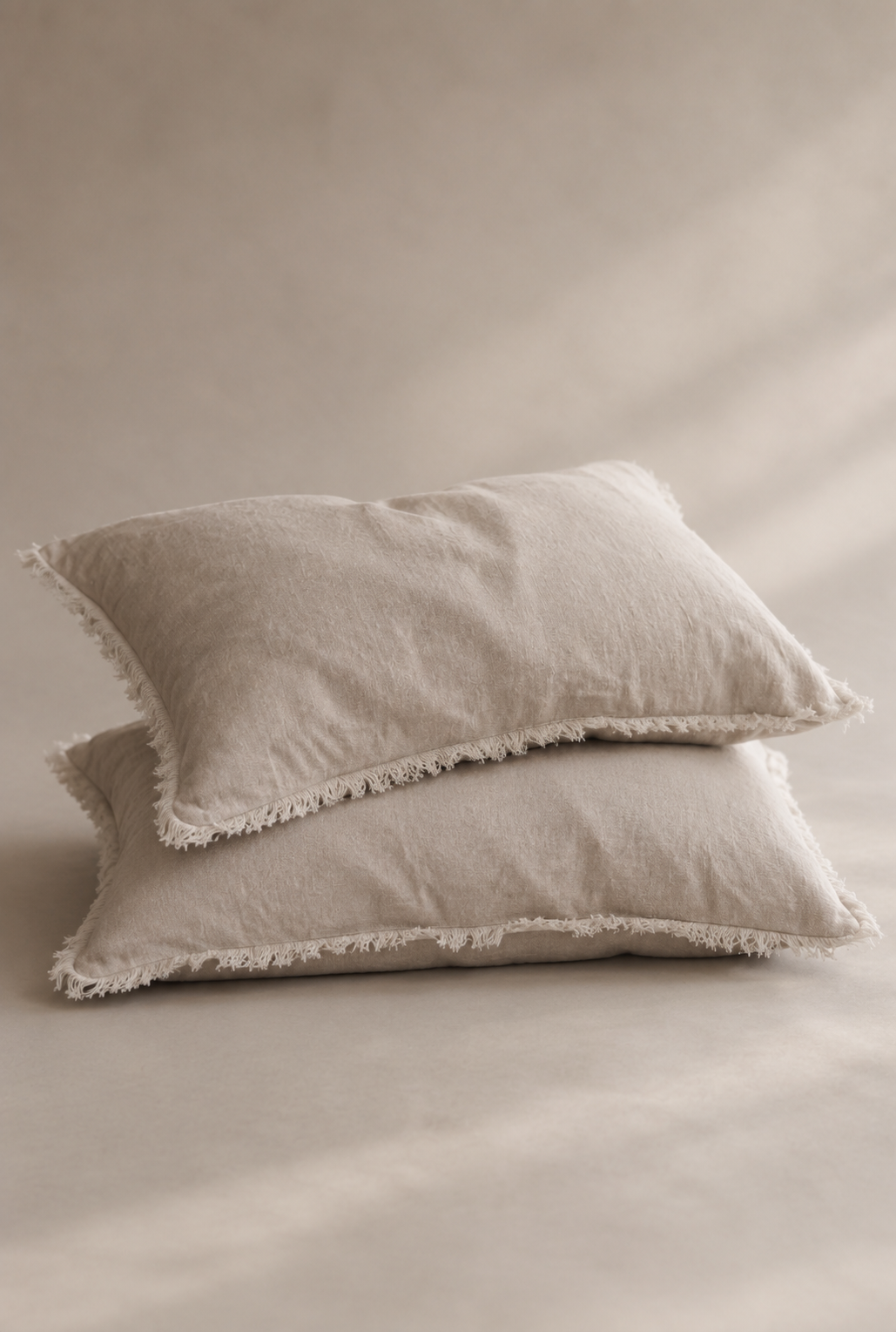 Set of two SOL Linen Sable frayed linen pillowcases for bedding, showcasing soft, textured fabric and frayed edges.