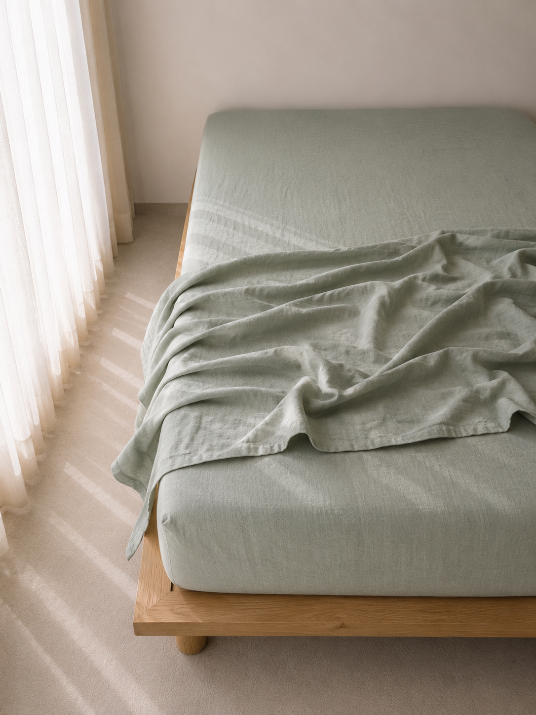 SOL Linen Sea Mist linen flat sheet displayed in a cozy bedroom setting, showcasing its soft, natural fabric and calming color.