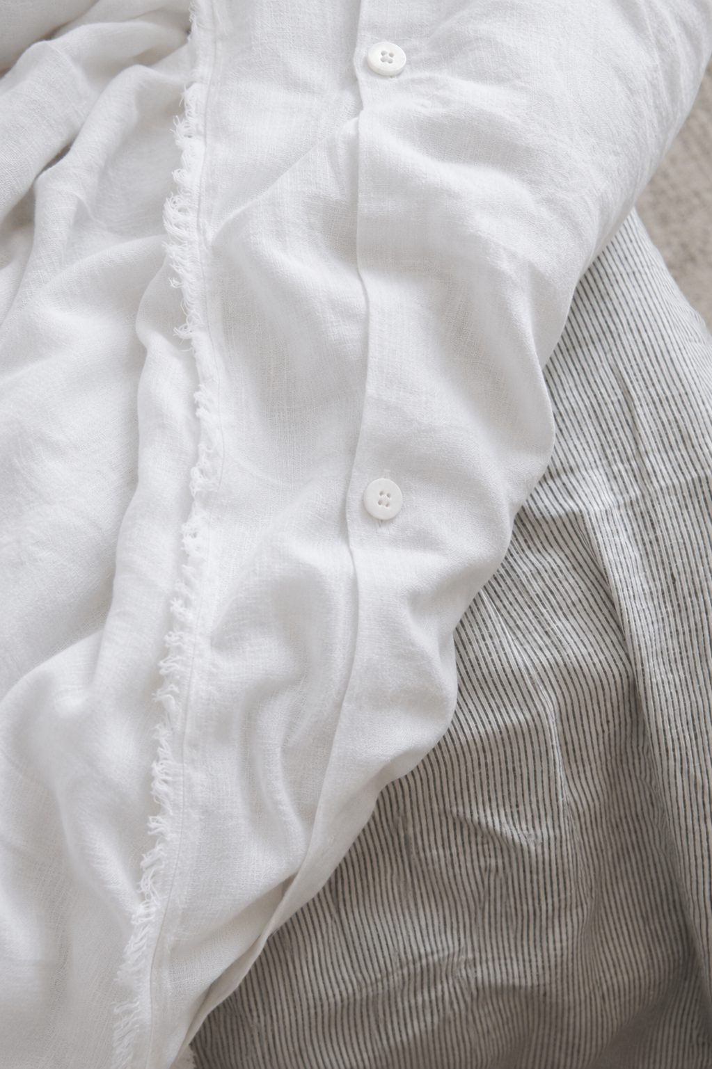 SOL Linen Whistler Frayed Linen Duvet Cover on a bed, showcasing its textured, frayed edges and soft, natural linen fabric.