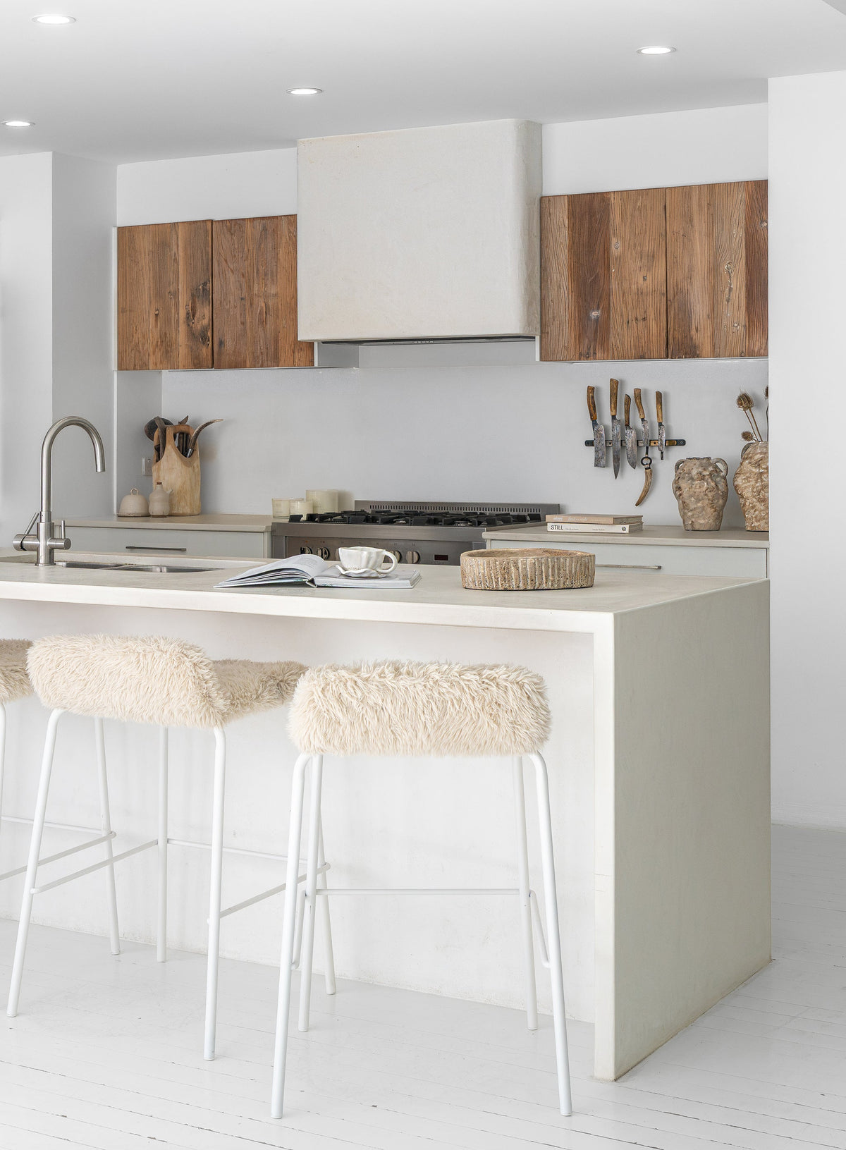 Hotham Barchairs arranged along a kitchen island with Ukoko Vases displayed behind and the Mayi Bowl styled on the benchtop.